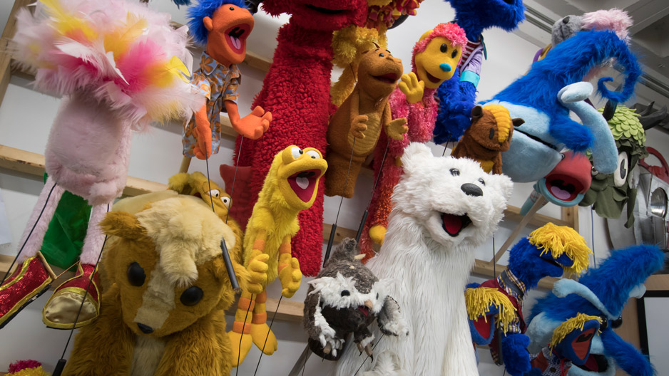 puppets hanging on the wall in a studio