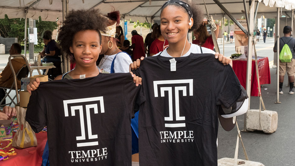 Girls hold up Temple 'T' T-shirts
