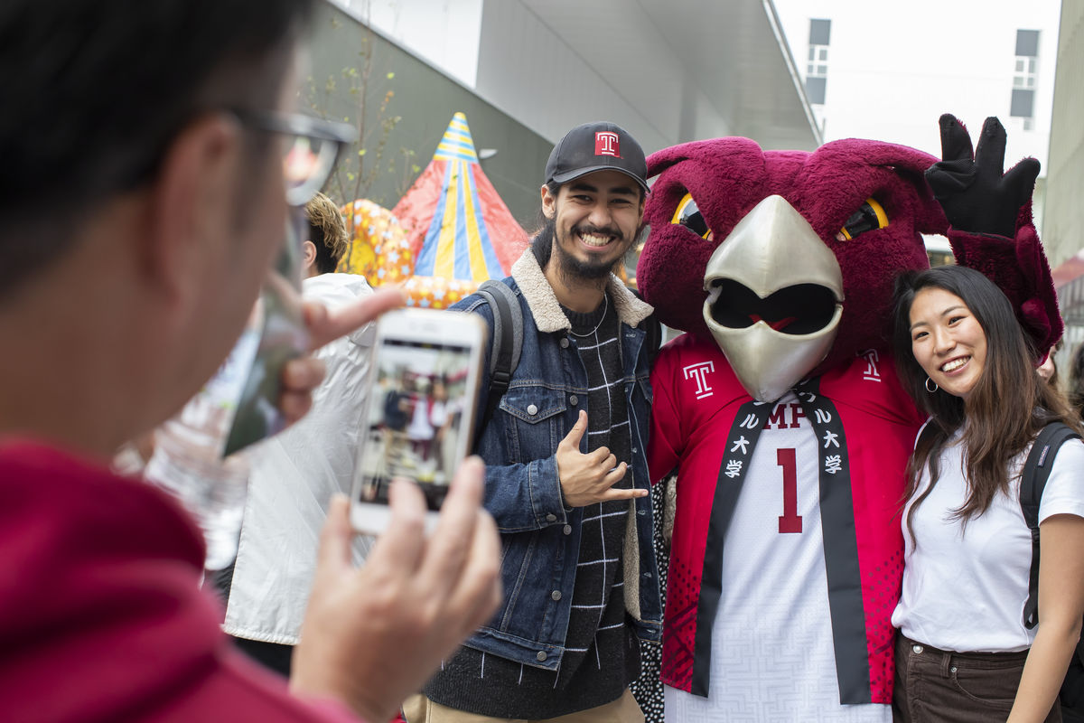Students take pictures with Temple University's mascot, Hooter the Owl. 