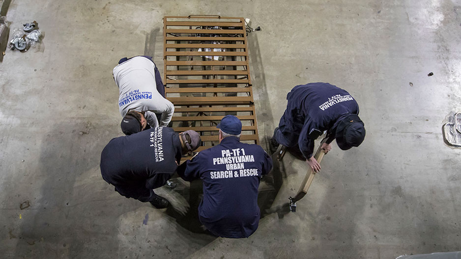 Task force members moving a hospital bed frame