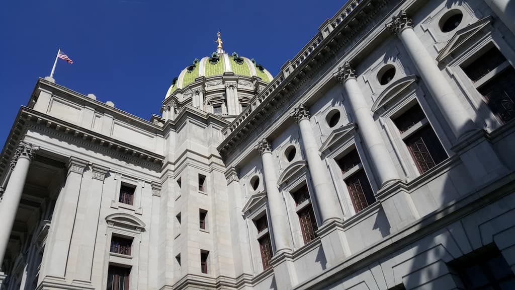 The exterior and dome of PA's Capitol building, with US flag flying