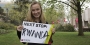 Maggie Andresen holding a sign that says "Next stop: Rwanda".