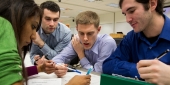 Four students around a table working on an assignment.