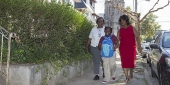 Two women and a young girl walking together through a residential neighborhood in North Philadelphia.