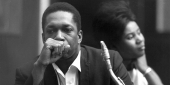 Coltrane sitting with his saxophone.