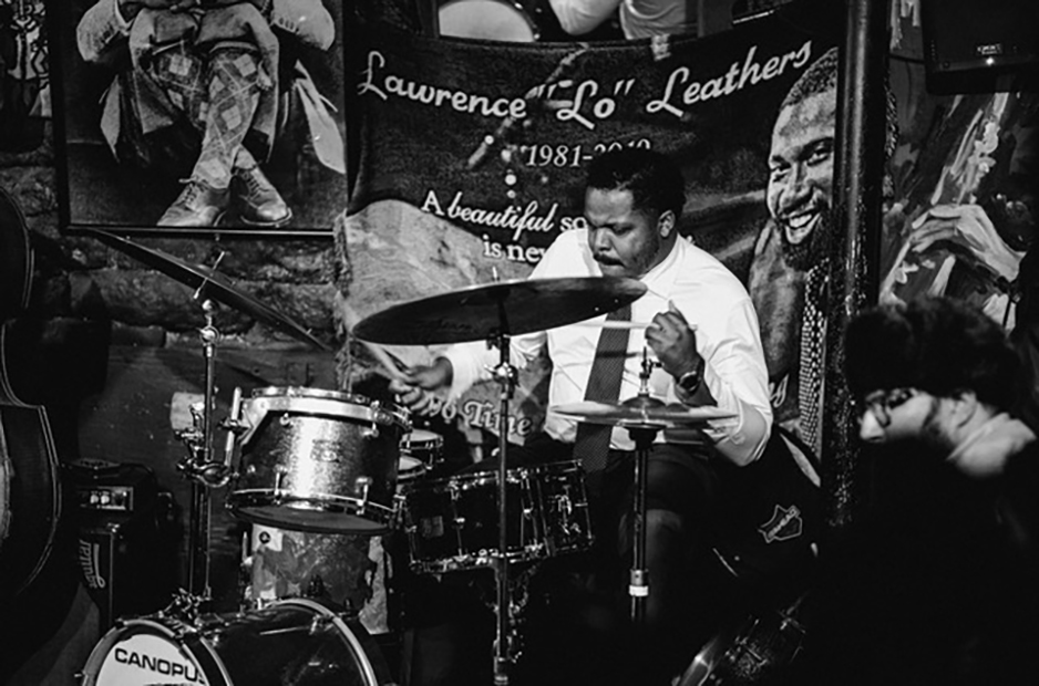Black and white image of Justin Faulkner at a drum set