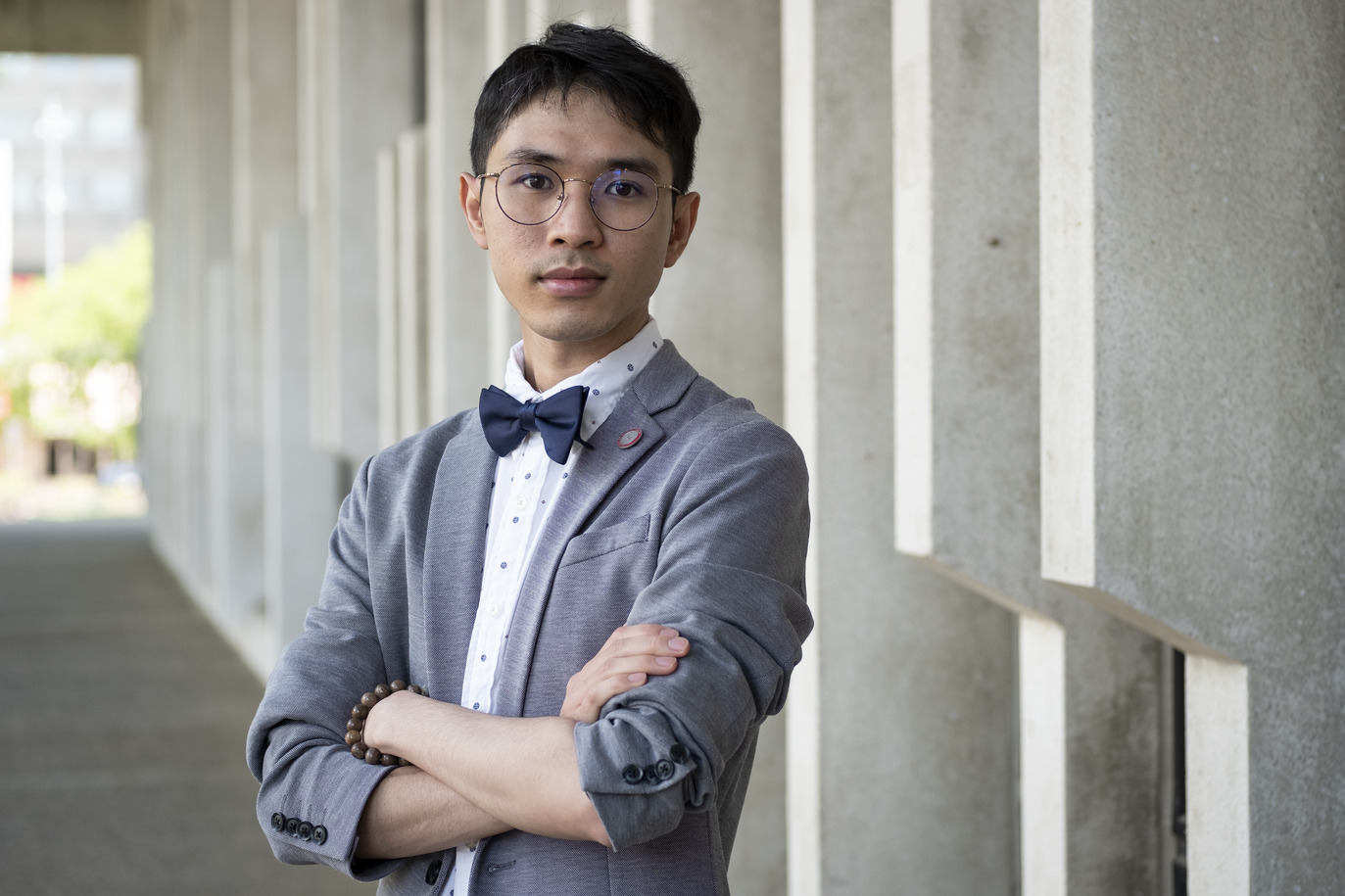 Hoa Vo standing in front of a building, wearing a bow tie.