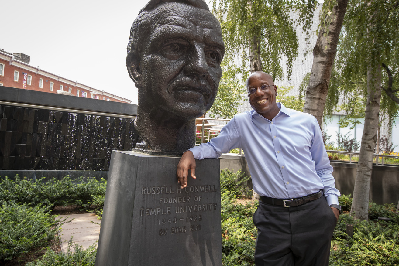 President Jason Wingard stands beside a bust of Temple University founder Russel Conwell.