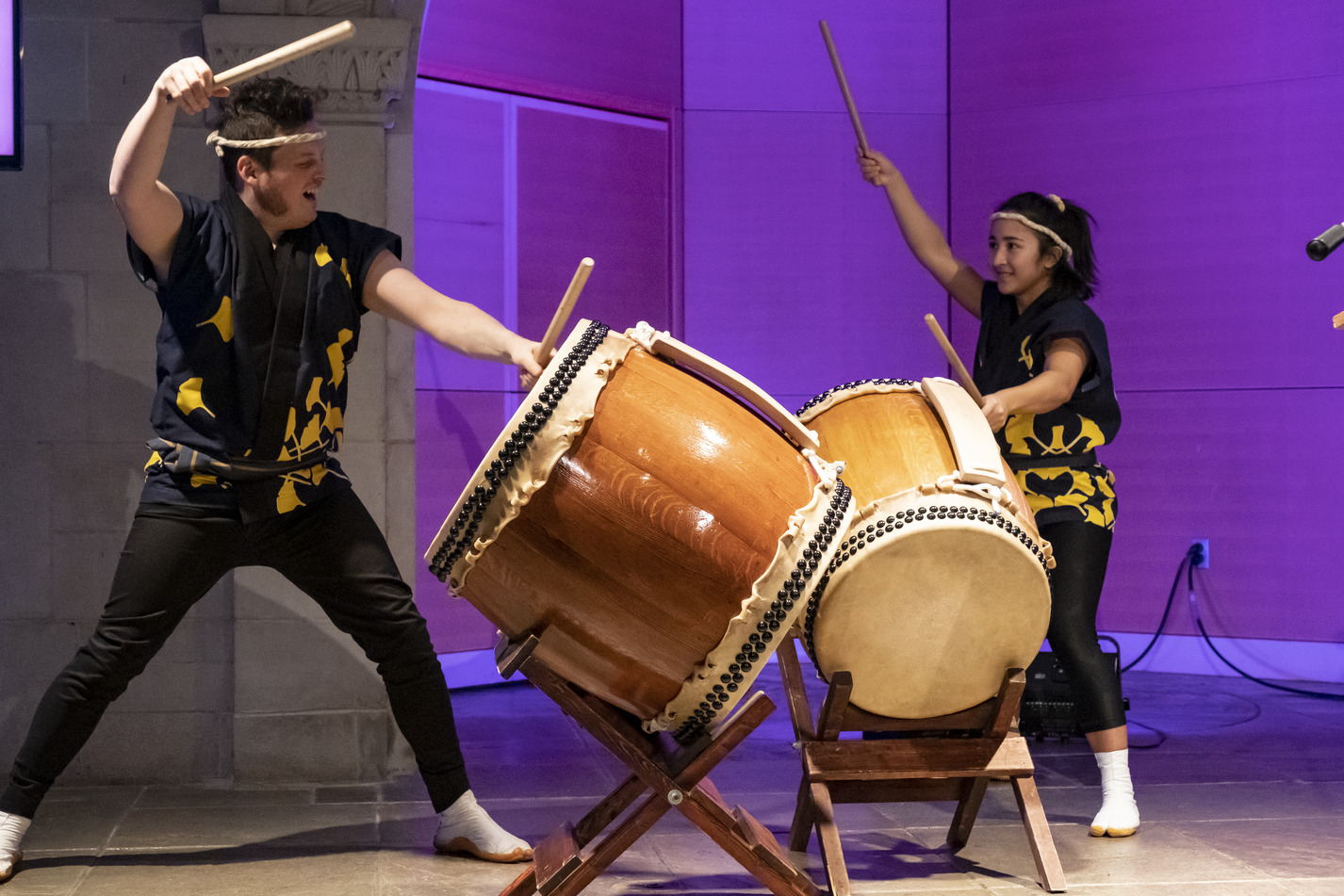 wo students banging on drums as part of a Taiko performance. 