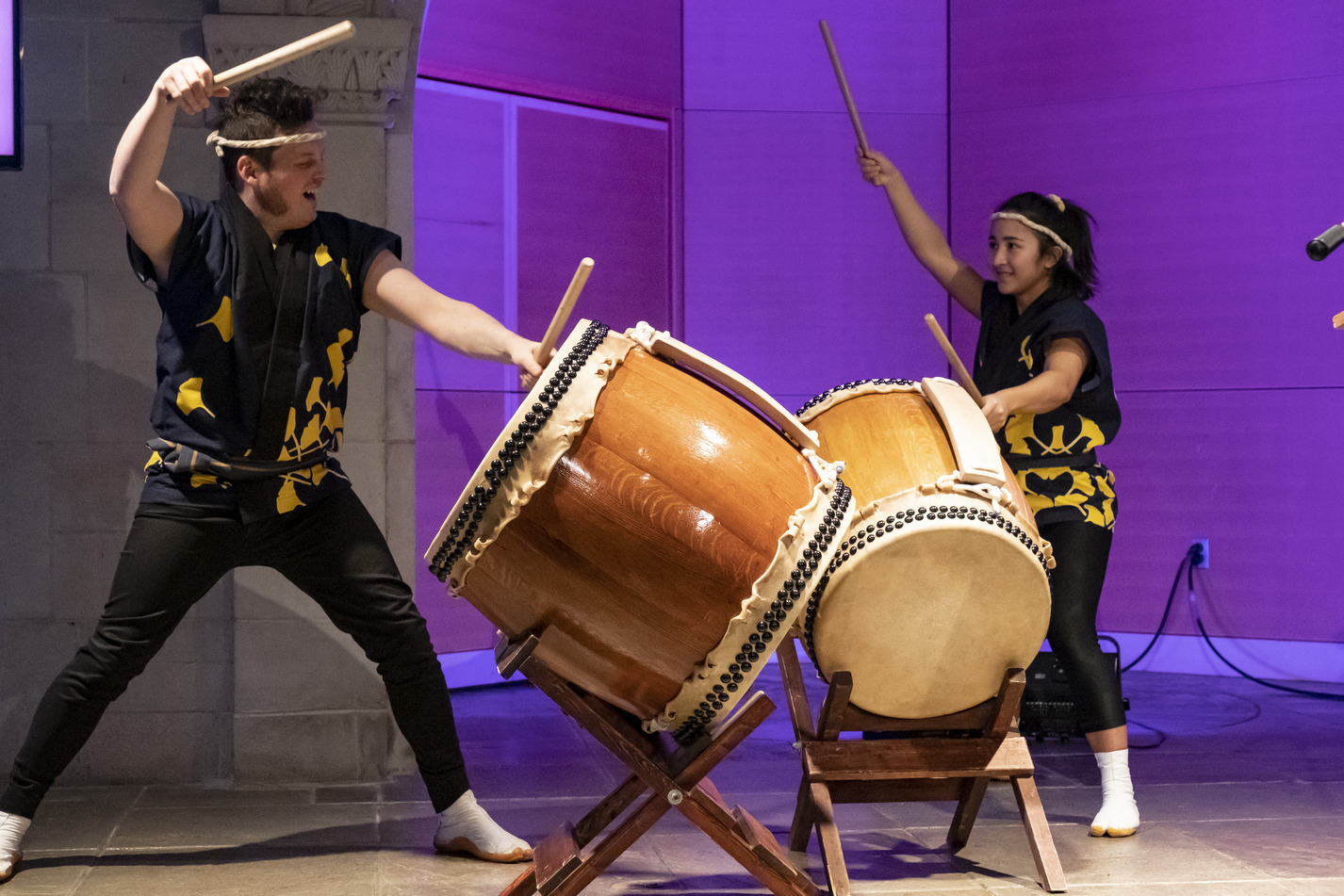 wo students banging on drums as part of a Taiko performance.