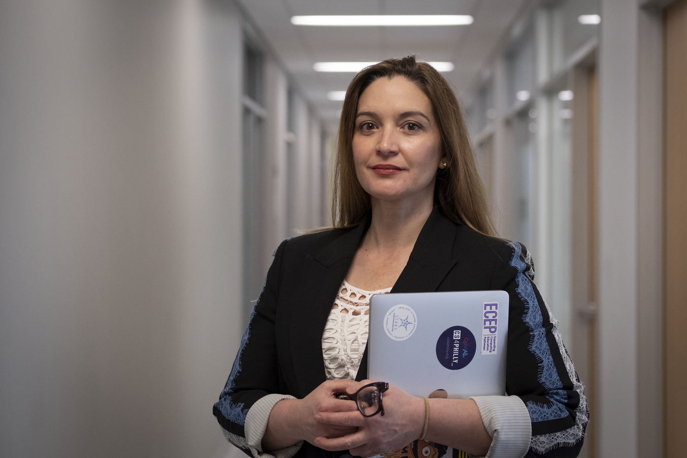 Image of Jamie Payton standing with her laptop in hand.