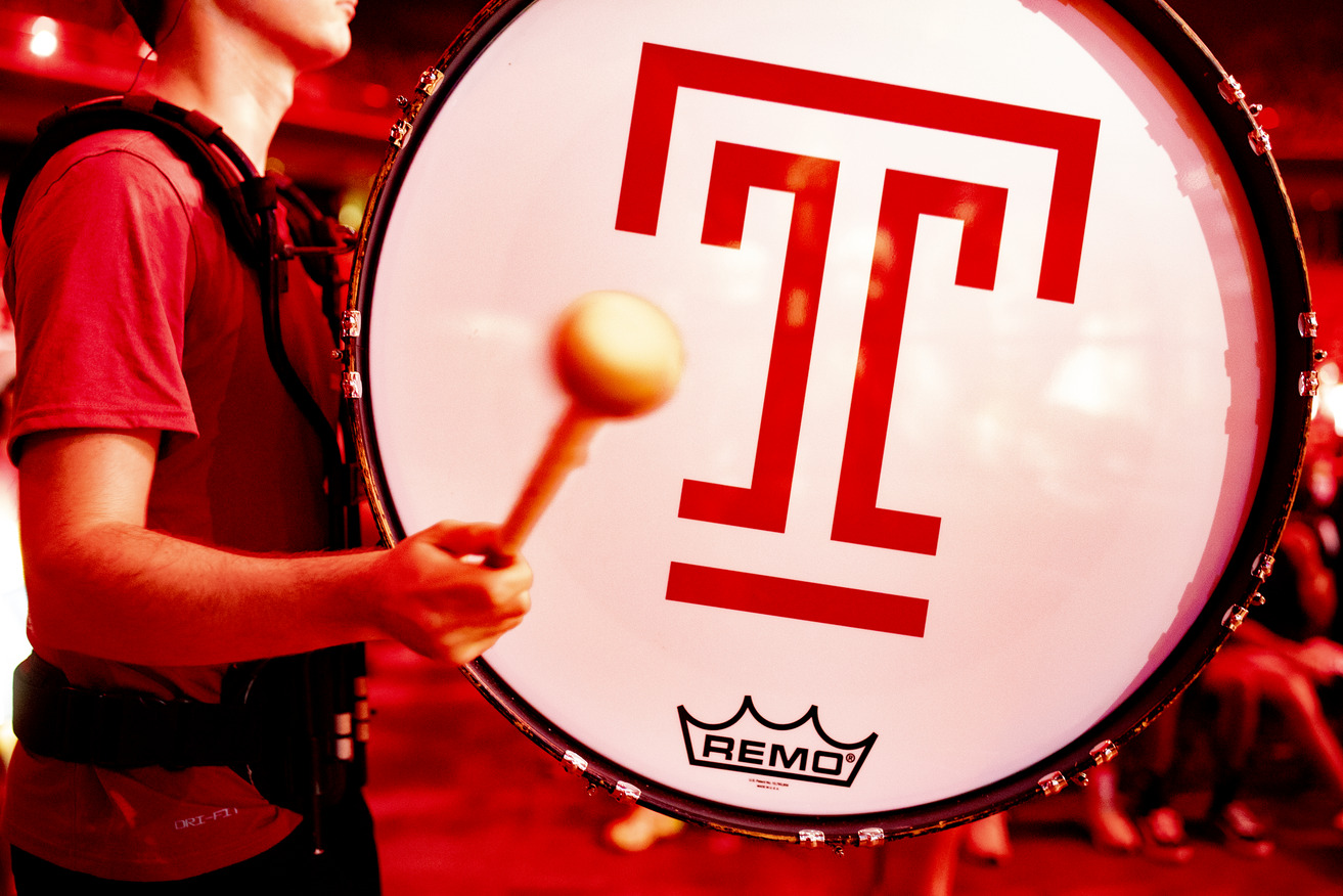 Student playing a drum with a T on it