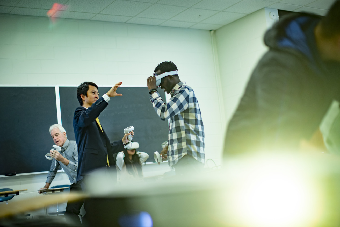 mage of Di Liu demonstrating virtual reality technology with teachers and students in a classroom.