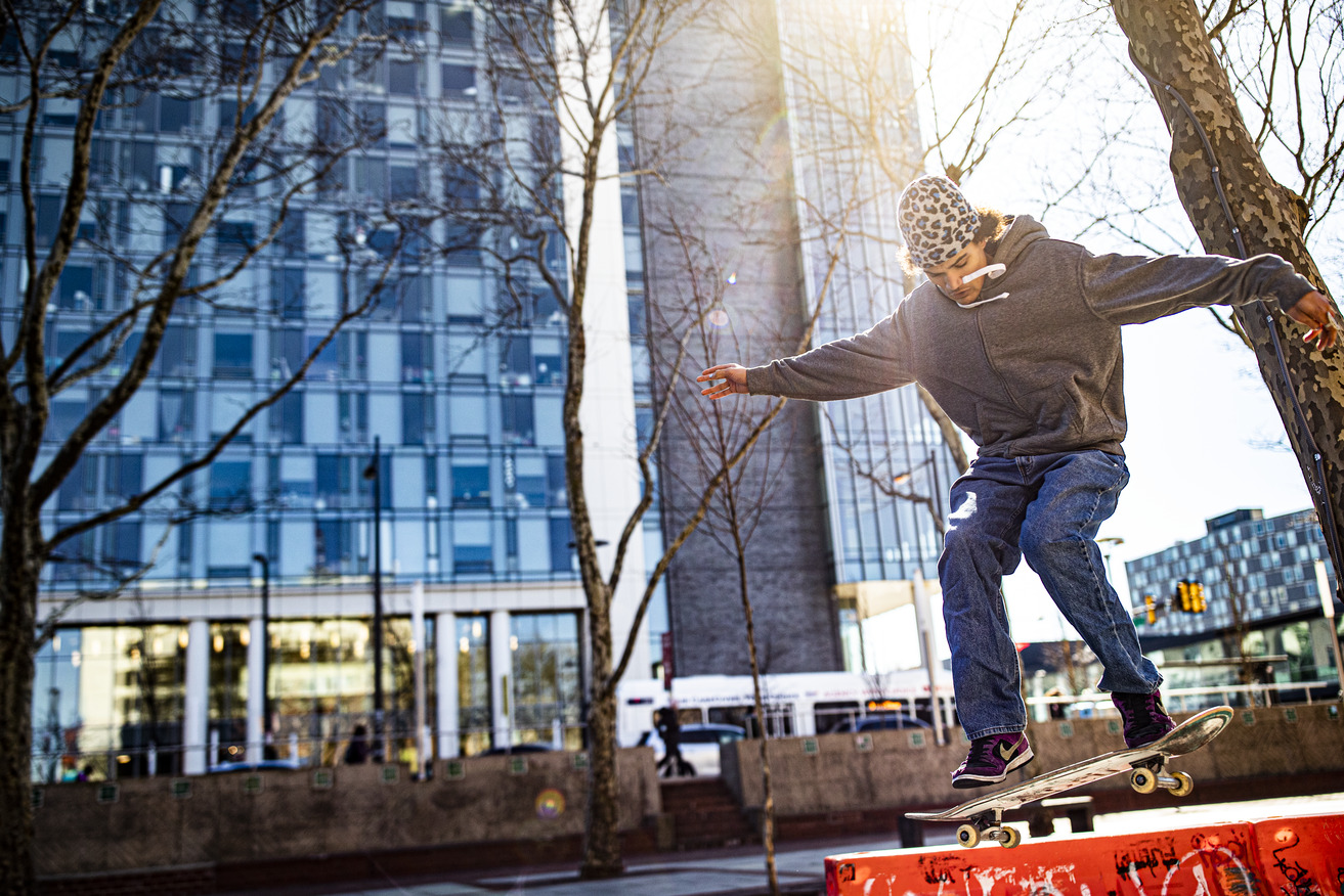 A man skateboarding on a safety barrier