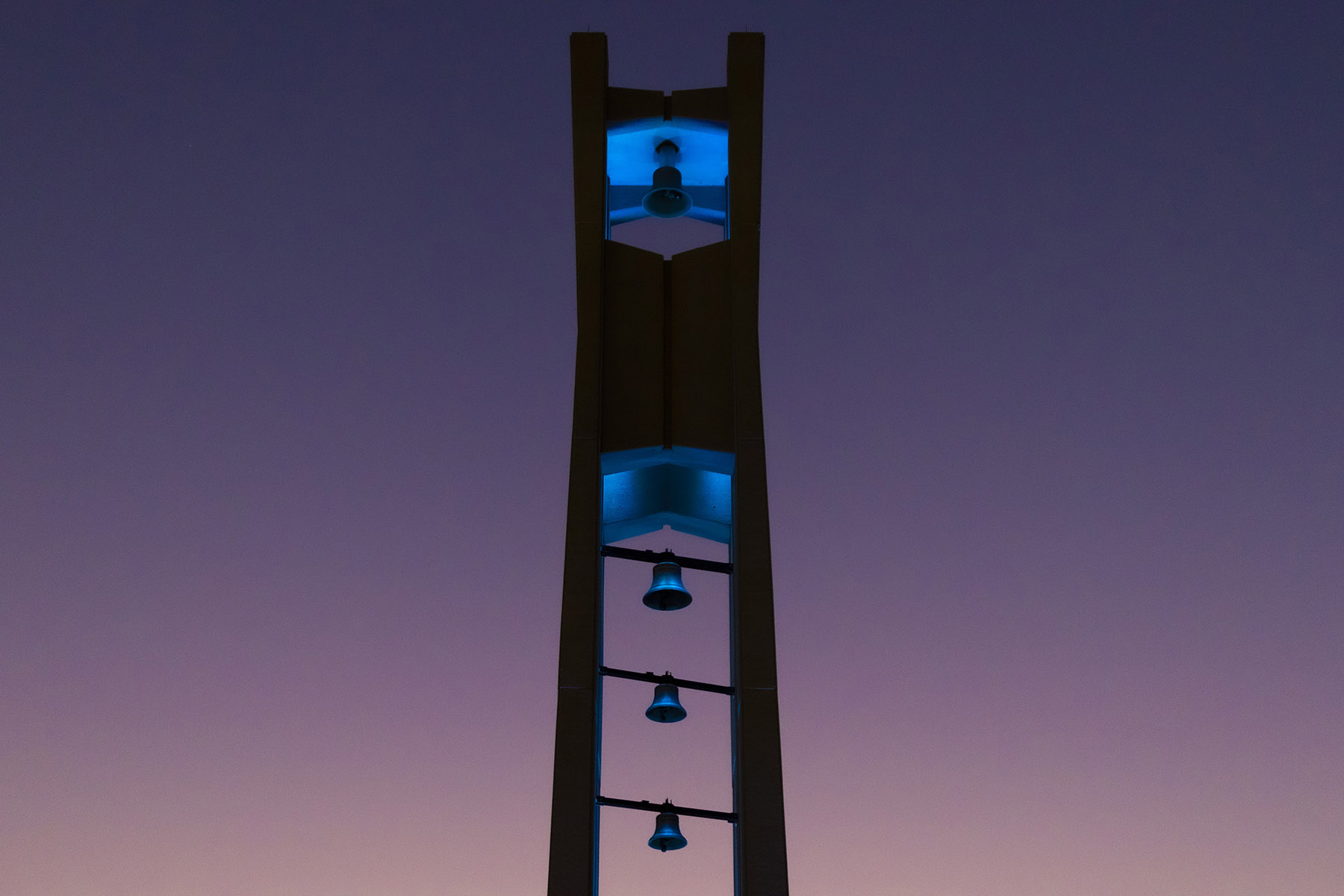 The Bell Tower at night lit up in teal