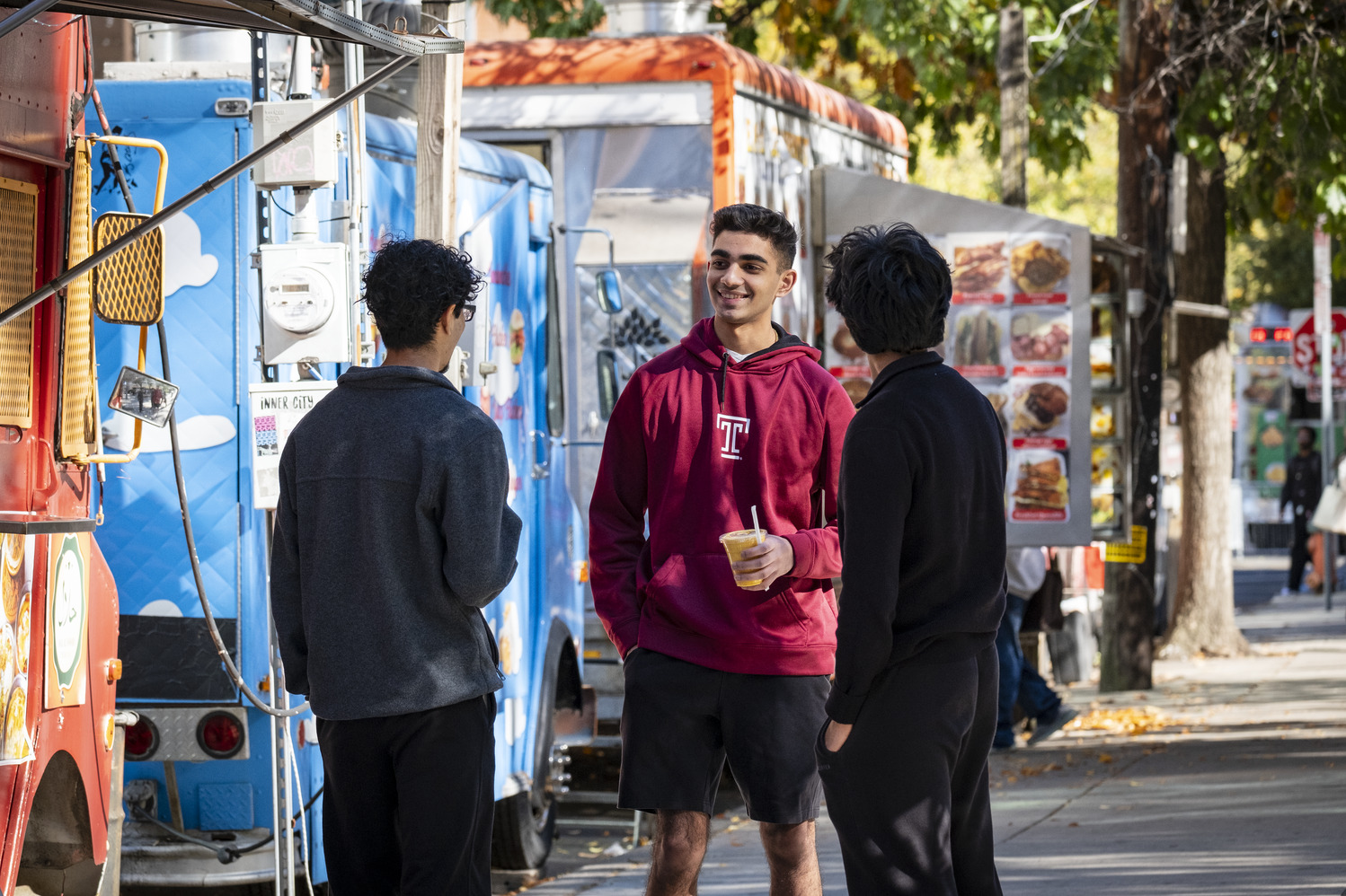 Students standing and talking near food trucks on Main Campus