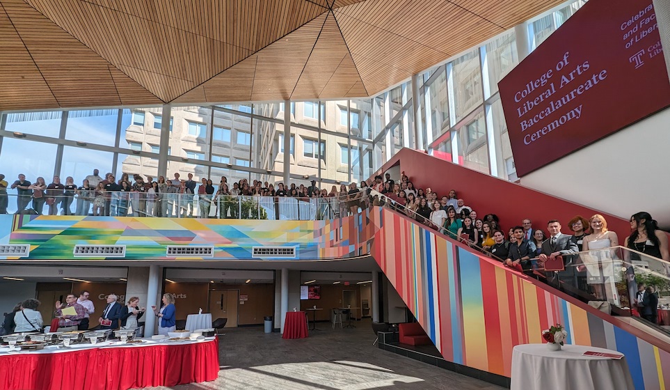 image of faculty, staff and students gathered for the ceremony and taking a picture on the steps in Mazur Hall