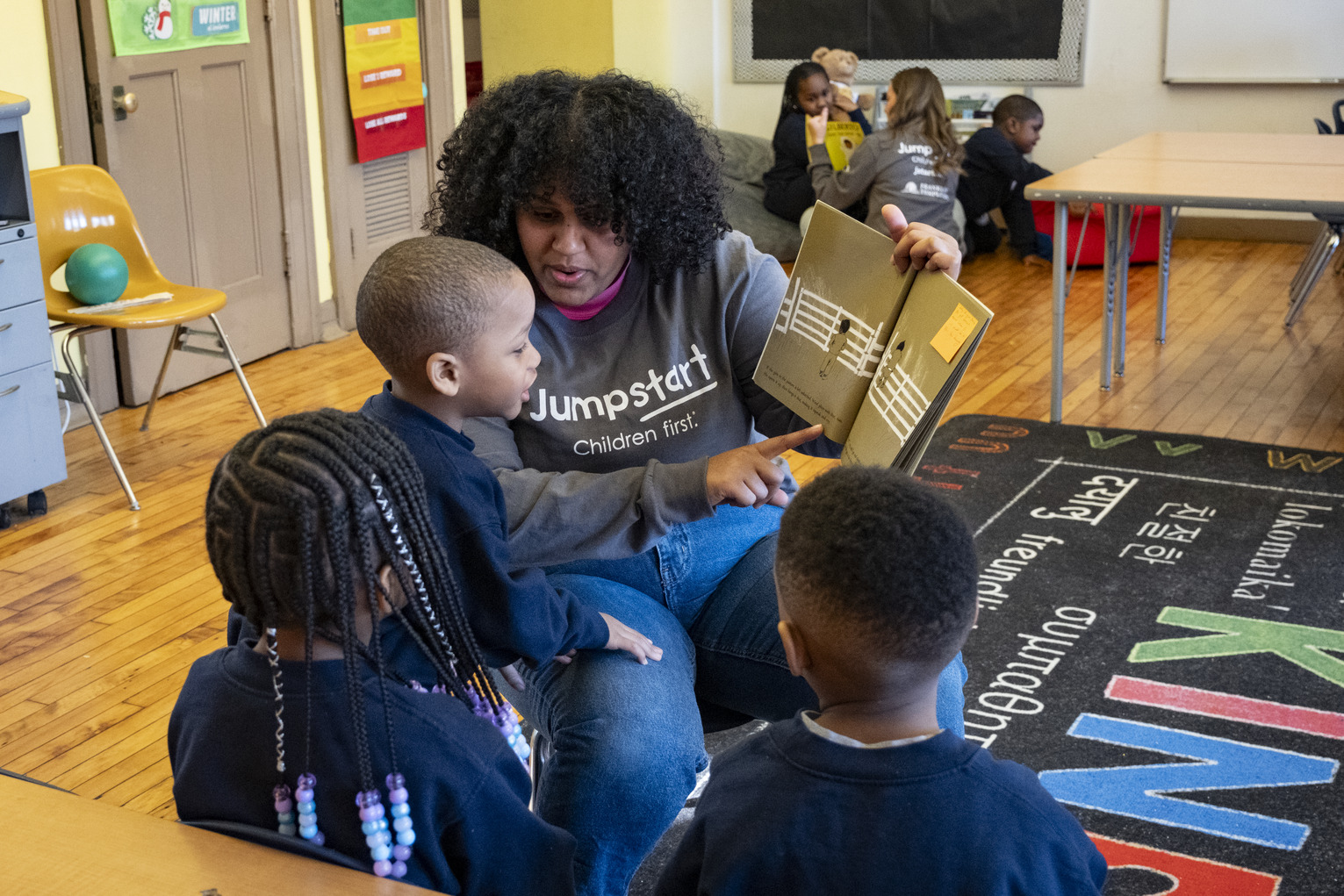 A Temple Jumpstart member reading to preschool children in a classroom at St. Malachy