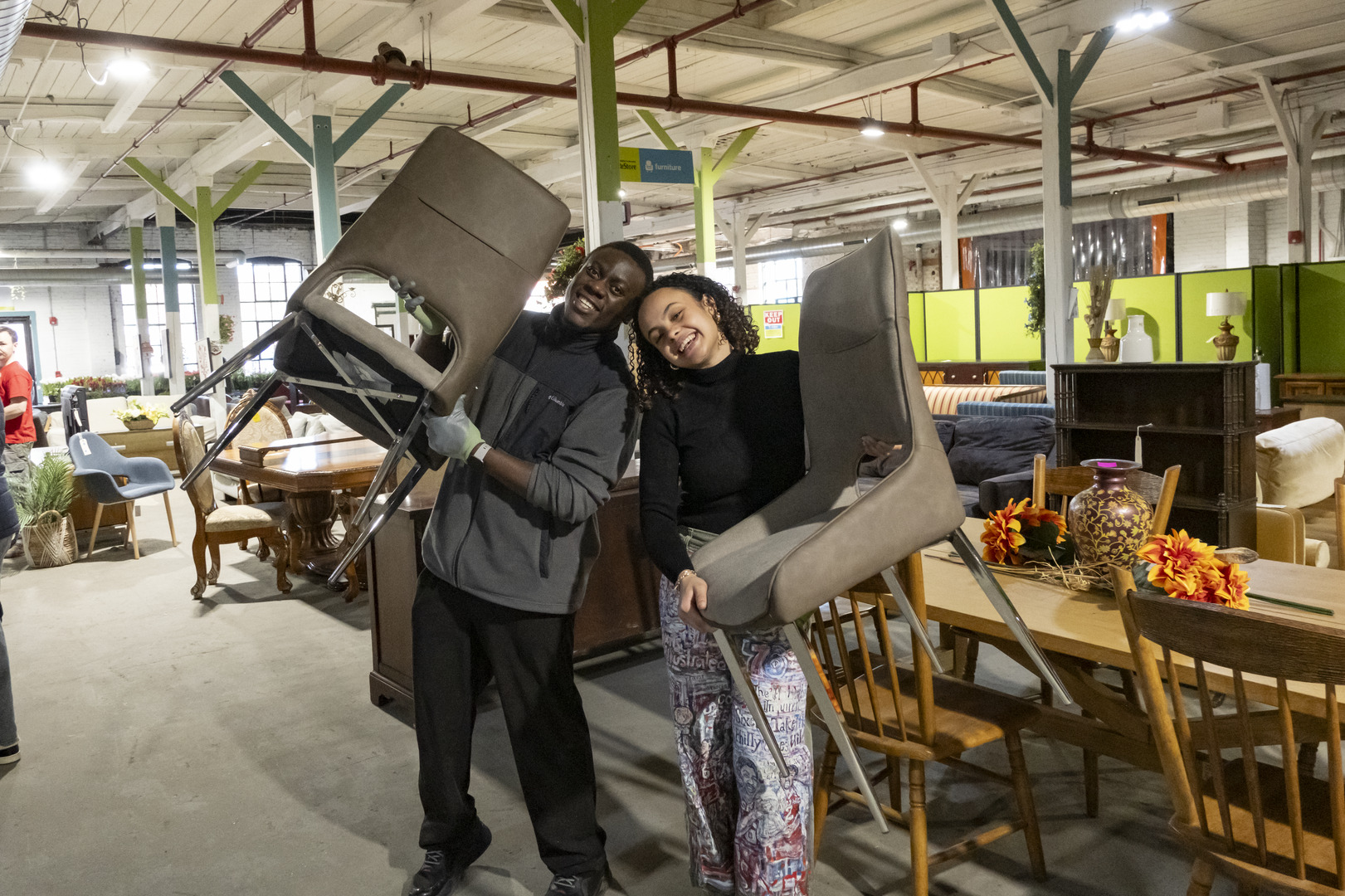 Students hold chairs in a ReStore