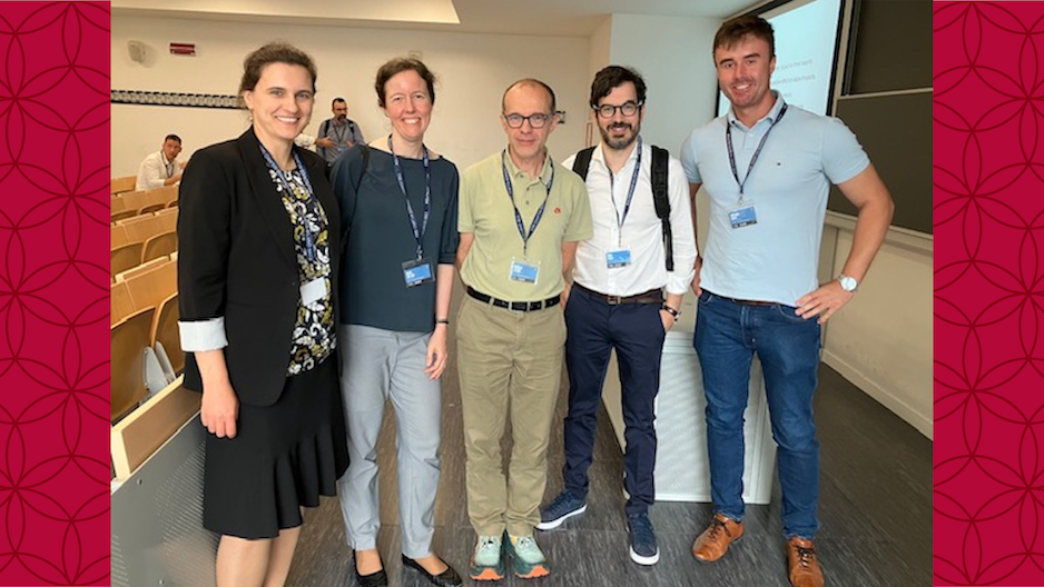 image of Olga and colleagues at a conference standing in a group smiling at the camera