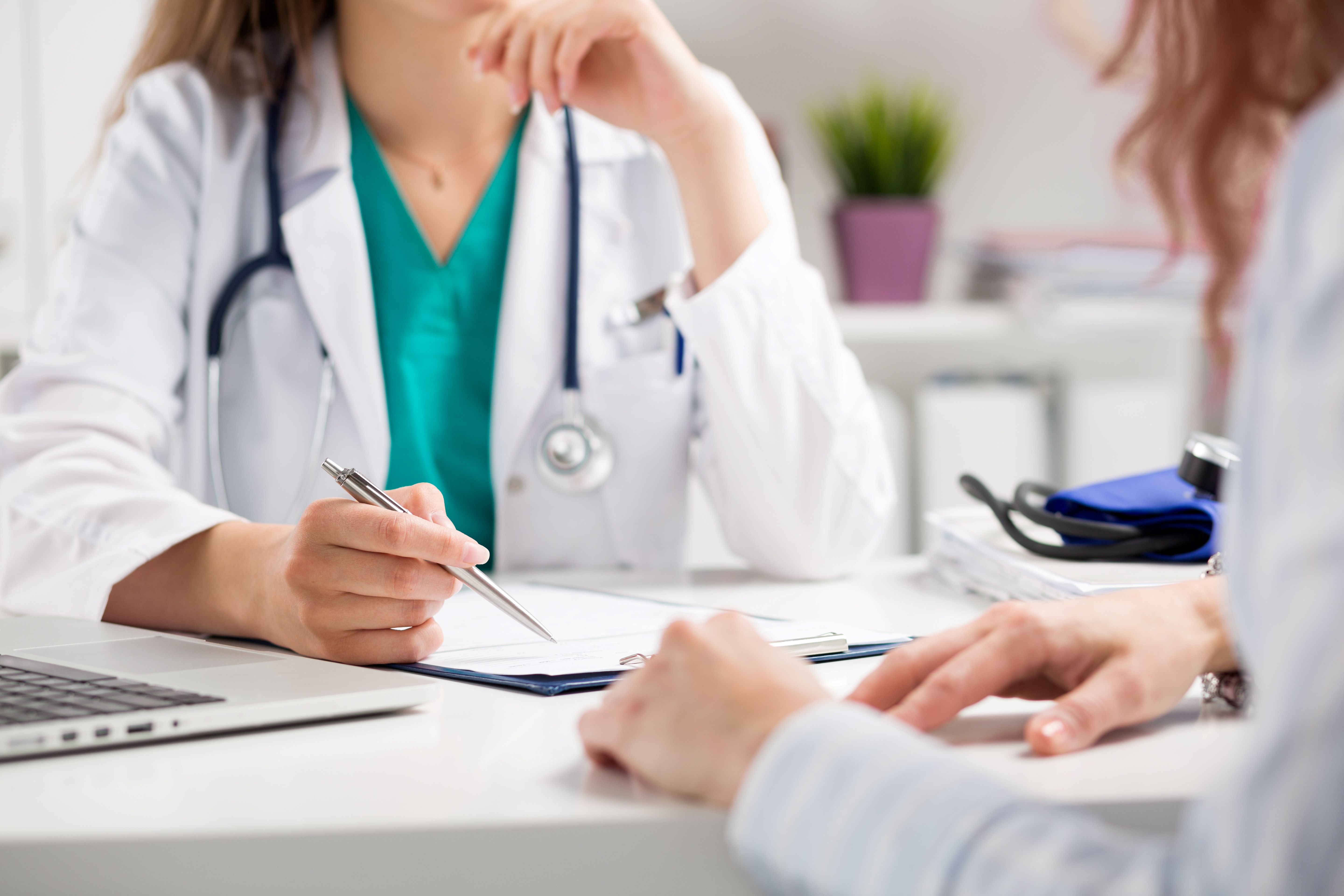 Person in doctor coat discusses with a patient