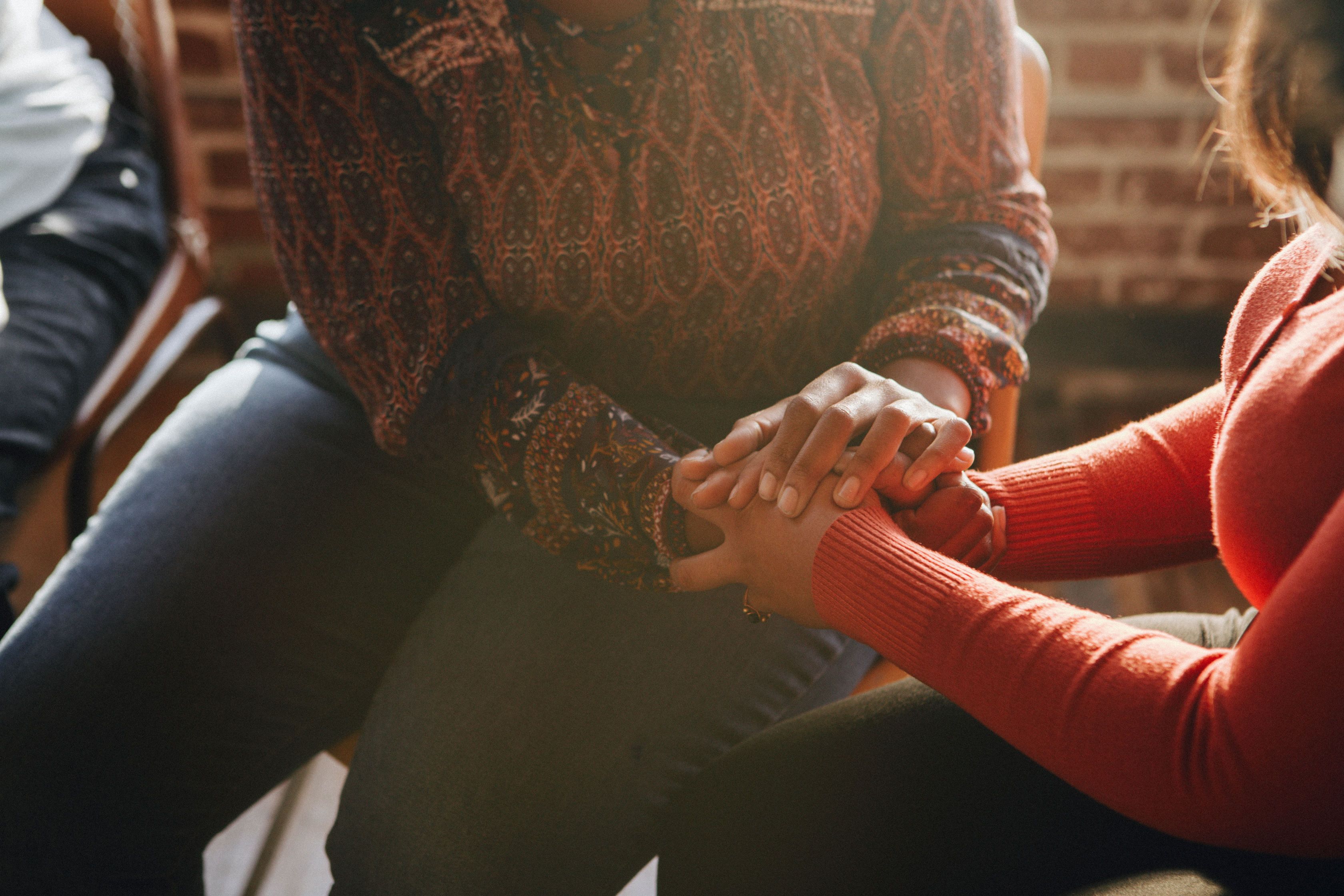 Two women clasping hands