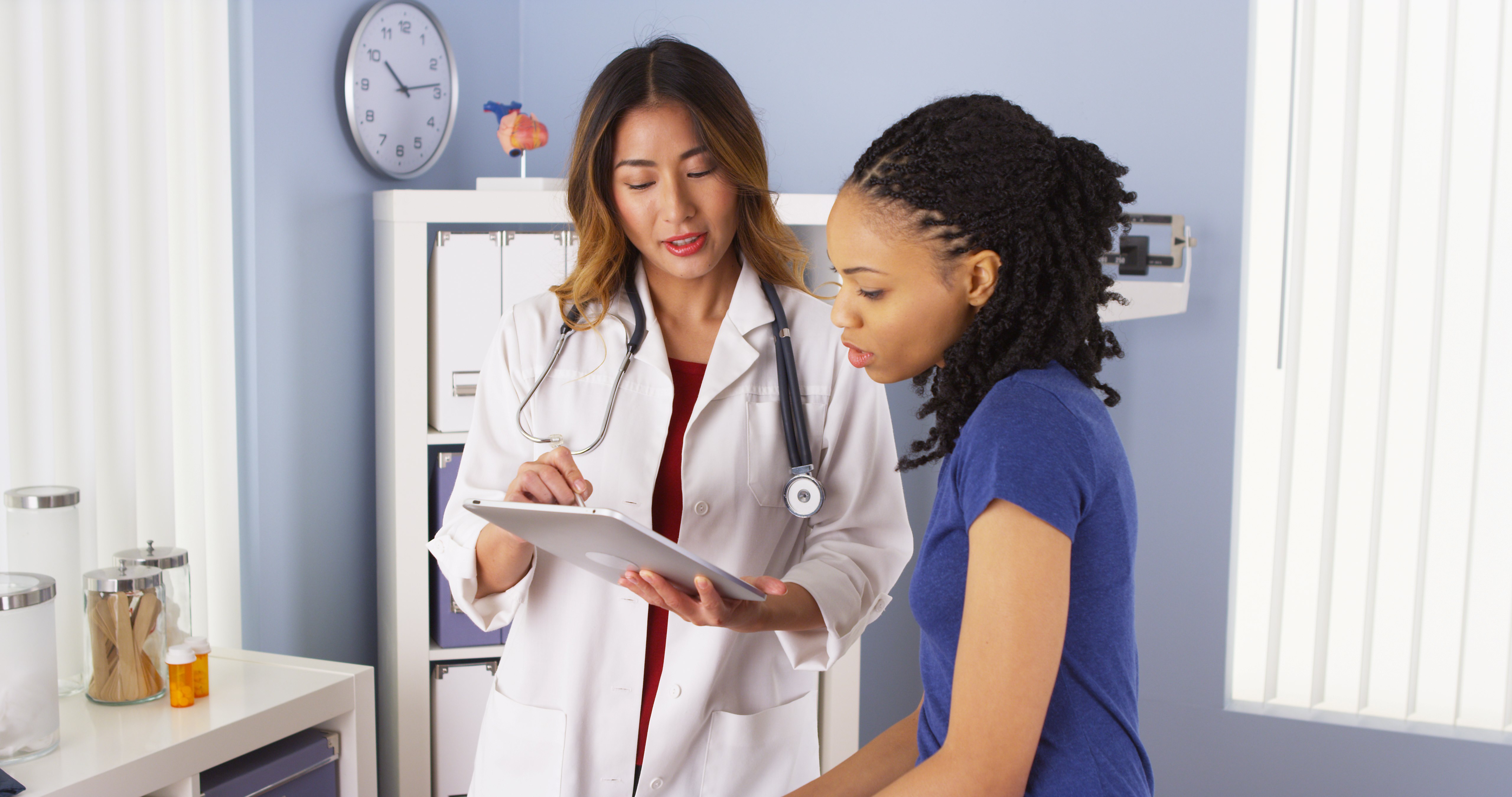 Female doctor talks to a woman sitting