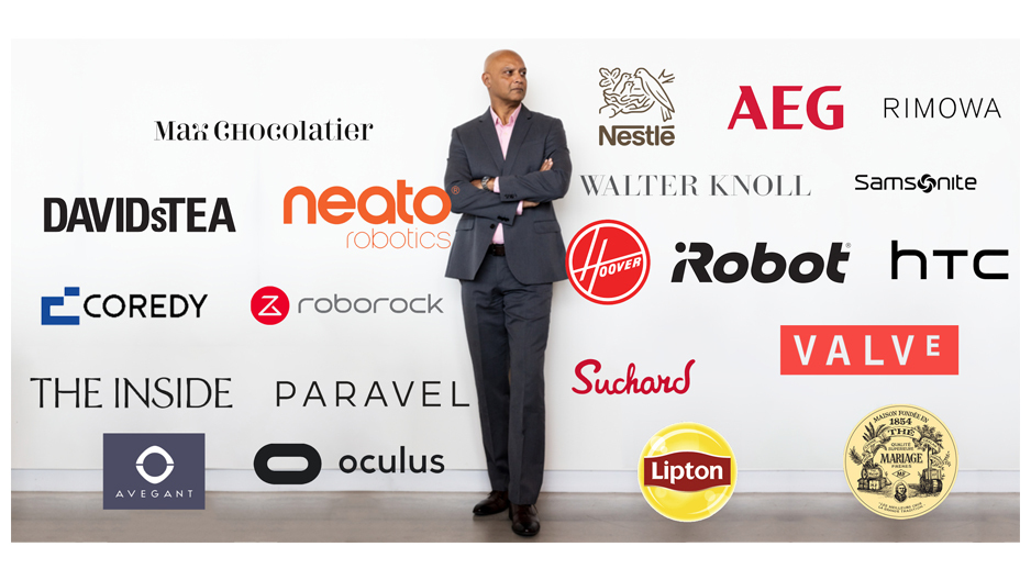 Joydeep Srivastava pictured behind a white wall with tons of brand logos.