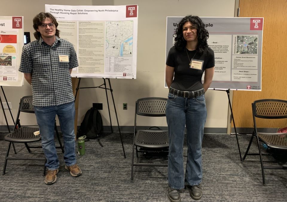 image of two students and their posters on display at the showcase