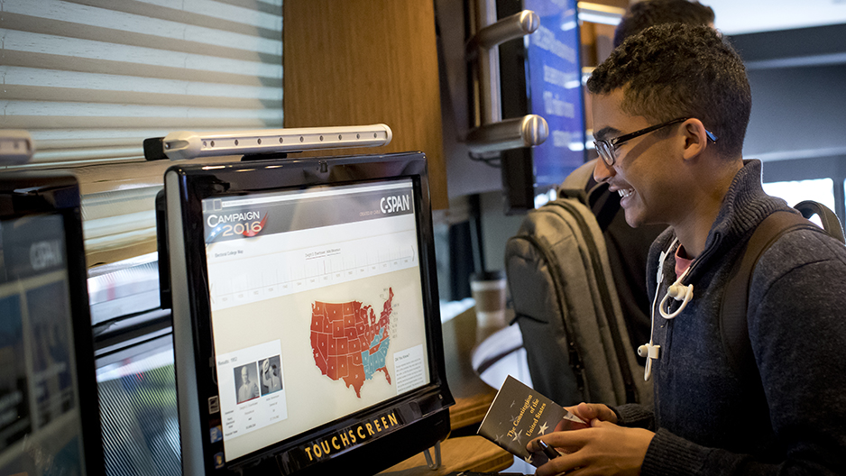 A student looking at a screen inside the C-SPAN bus.