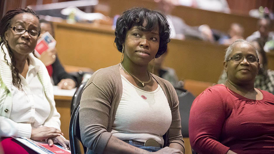 Three women sitting in an auditorium. 