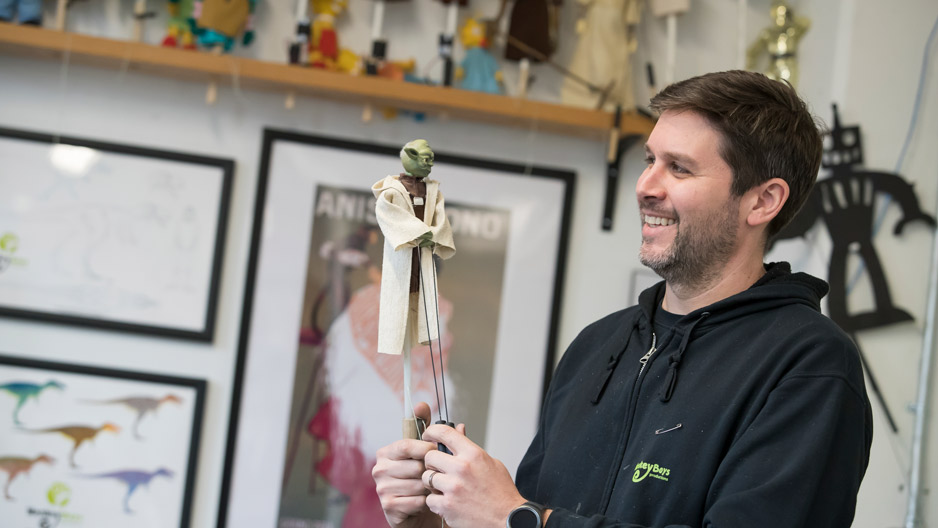 Michael Latini holding a mini puppet of "Yoda"