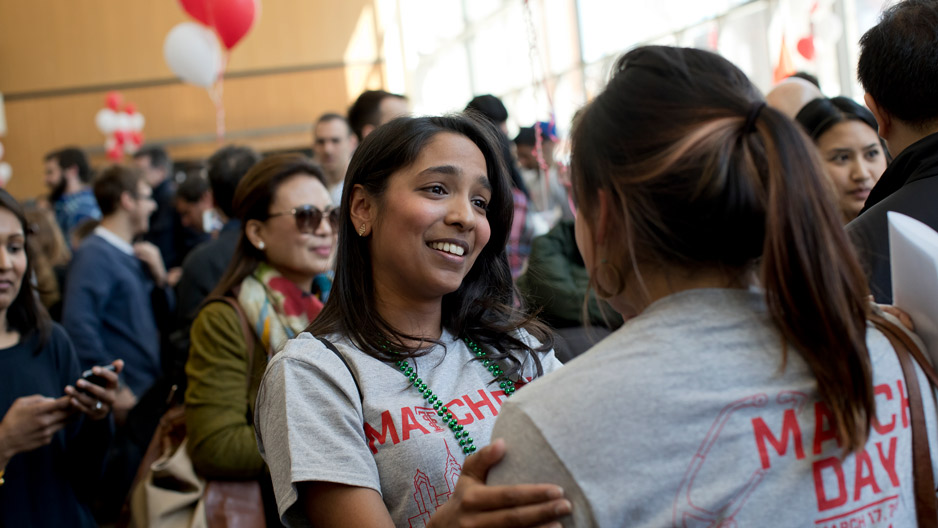 med student Pamela Boodram talking to another student.