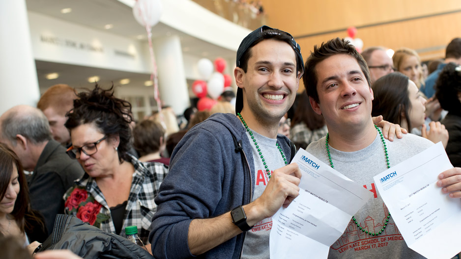 med students Cody Nathan and John St. Angelo holding up their match letters.