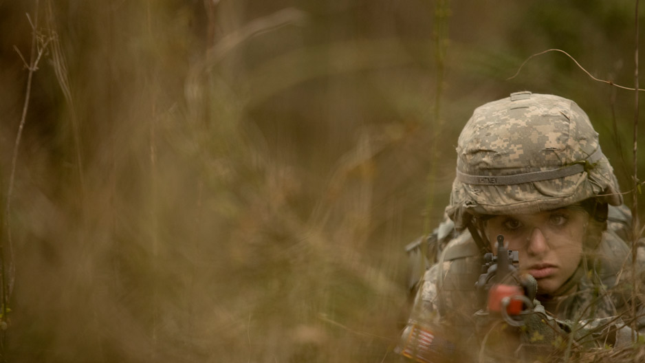 An ROTC student with a helmet and rifle during a training session