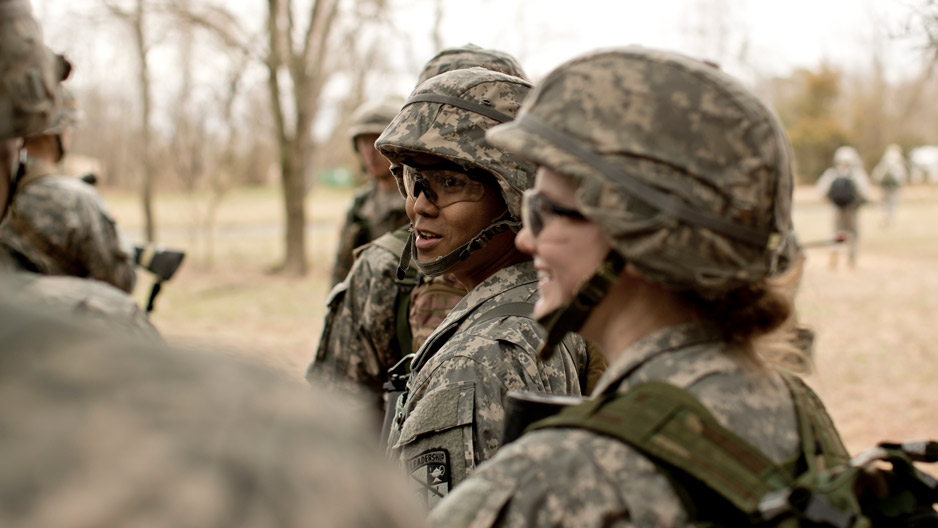 ROTC students wearing helmets and fatigues talking