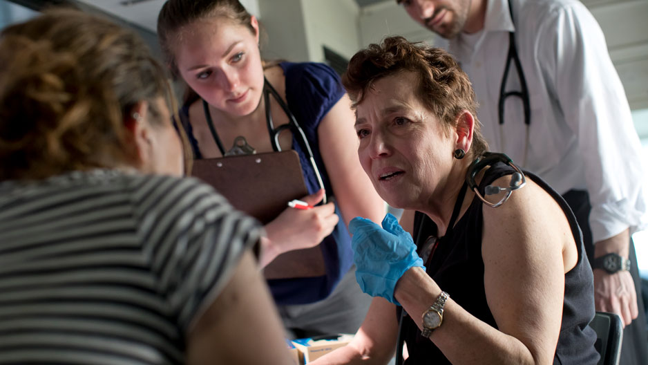 Ellen Tedaldi, professor of medicine, works with students and a patient