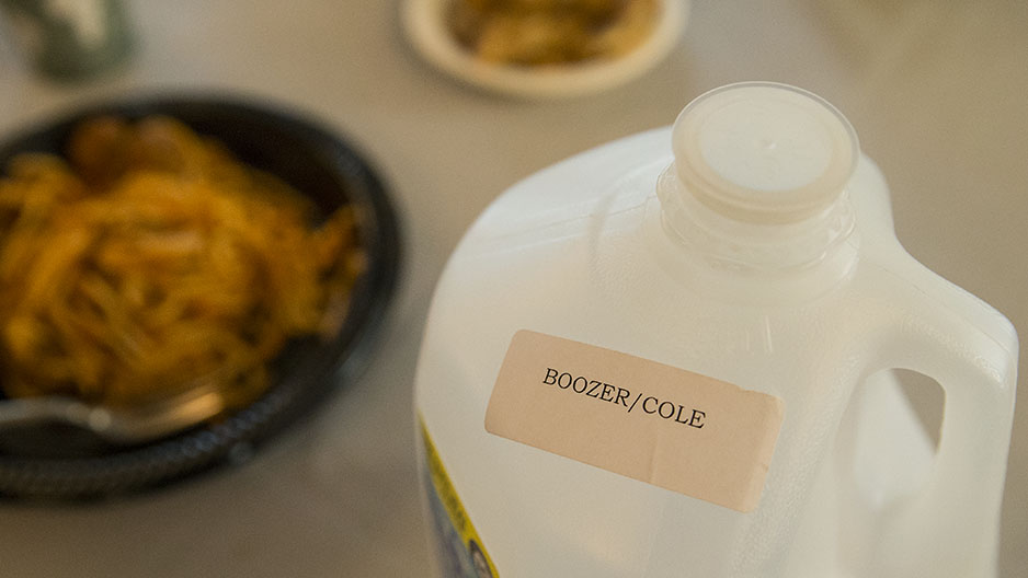 A gallon water jug with a stick that says Cole Boozer.