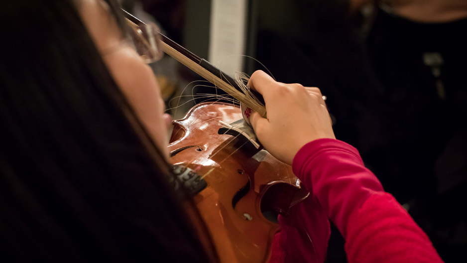 A woman playing a violin with a broken bow