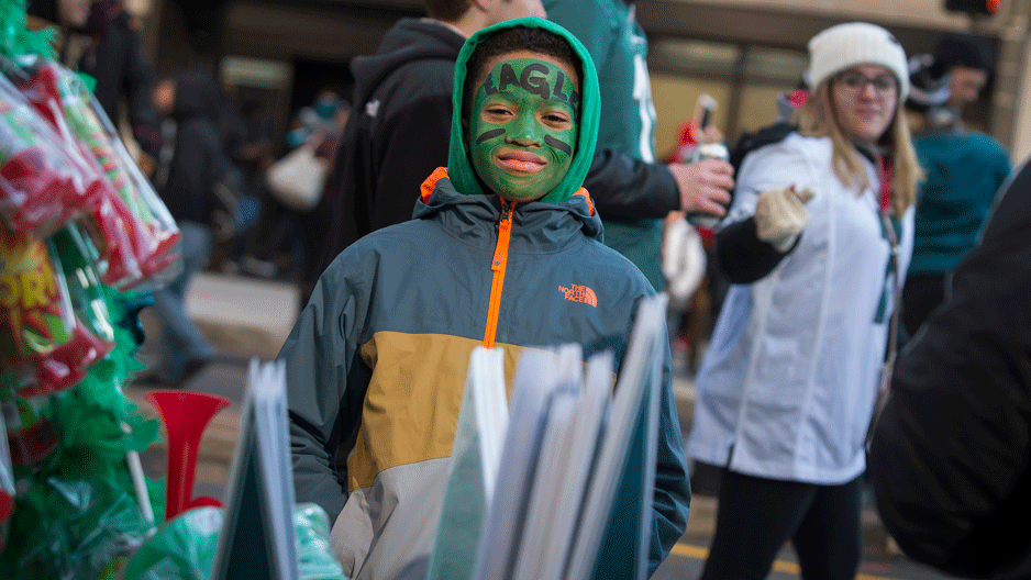 Little boy wearing green Eagles face paint