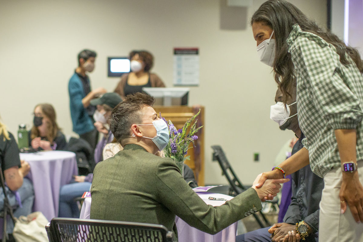 Image of Gingi Wingard shaking hands with a student