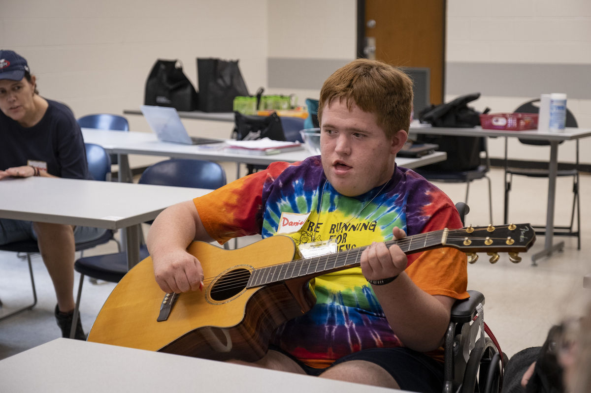 ACES participant holding a guitar during music therapy