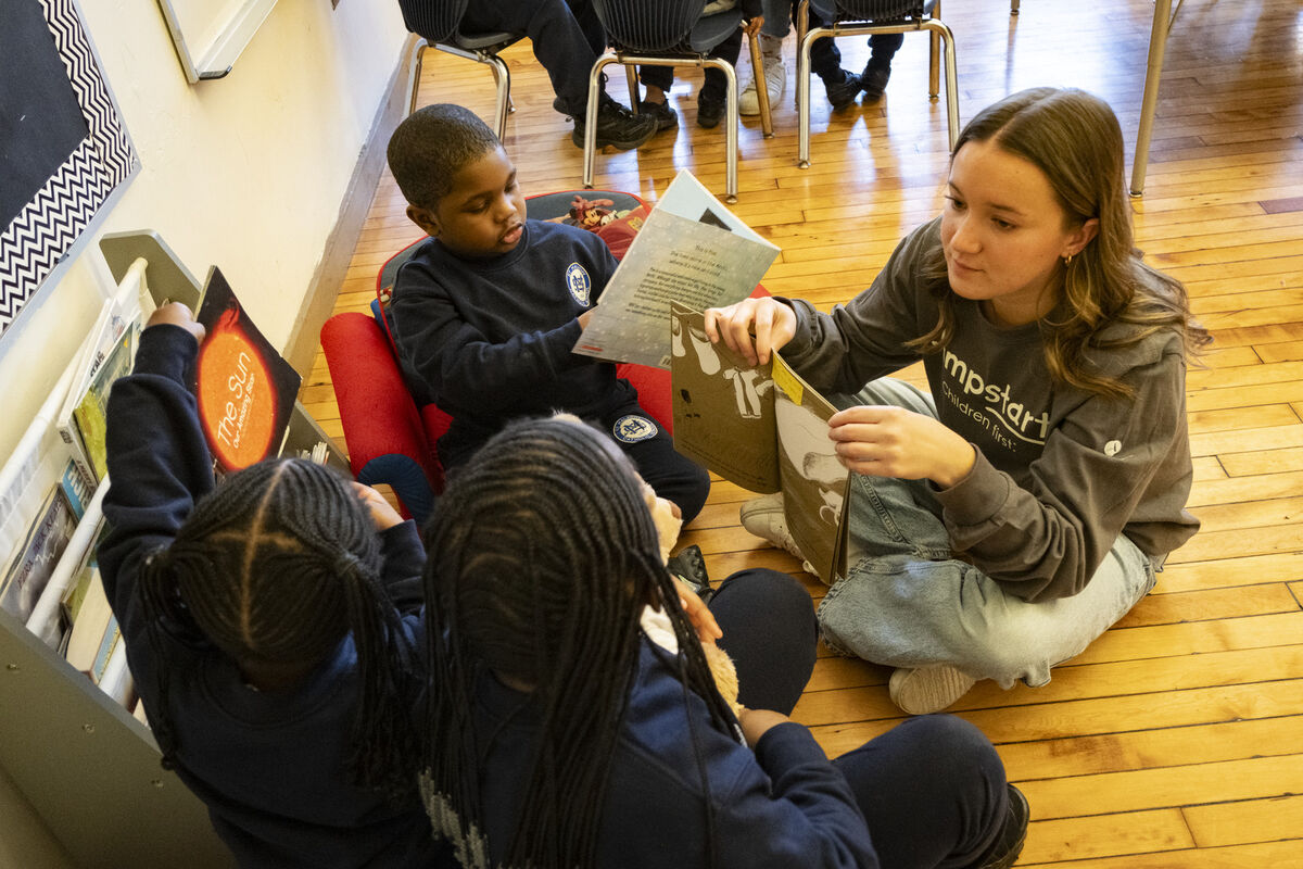 A Temple Jumpstart member reading to preschool children in a classroom at St. Malachy