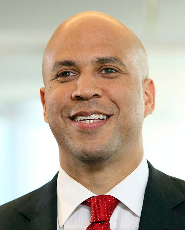 Senator Cory Booker wearing a black suit and red tie