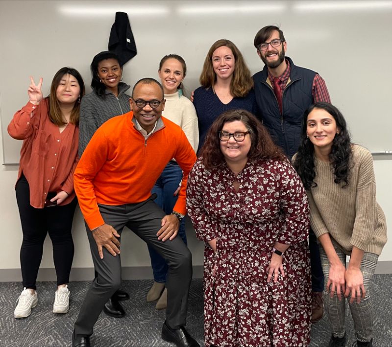 Dean Davis poses casually with group of doctoral students