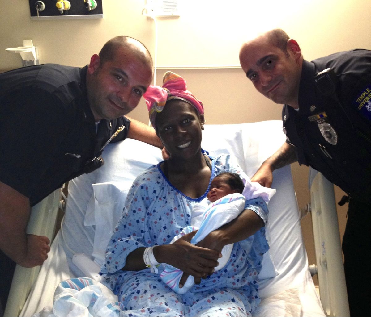 A photo of two Temple Police Officers from 2013 with the baby they helped deliver and her mother. 