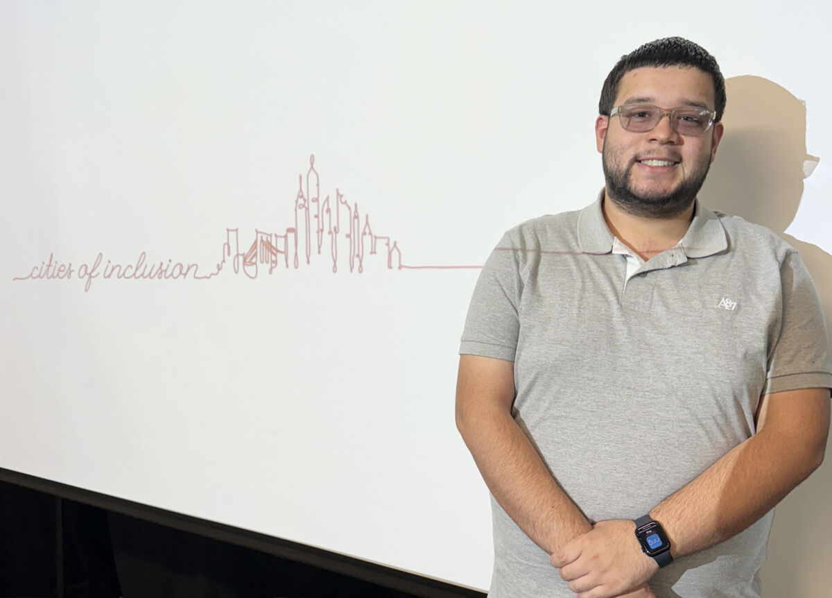 Delgado poses in front of a graphic reading 