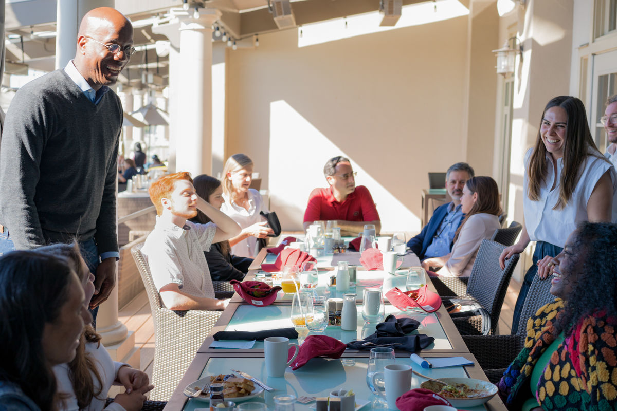 Image of President Jason Wingard speaking with others at breakfast