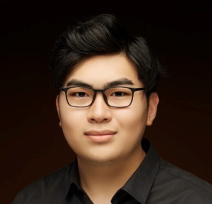  Zenan Shen wearing a black shirt and black glasses in front of a black backdrop.