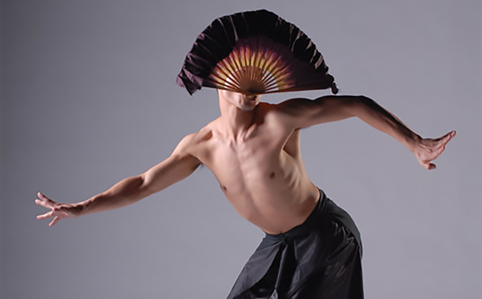 Male dancer with fan on gray background